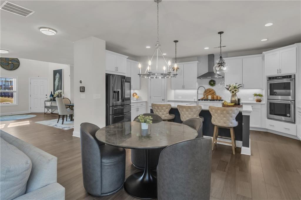 244 Wild Rose Circle Canton, GA 30115 - Photo 17 of 55 a kitchen with kitchen island a dining table chairs stainless steel appliances and cabinets