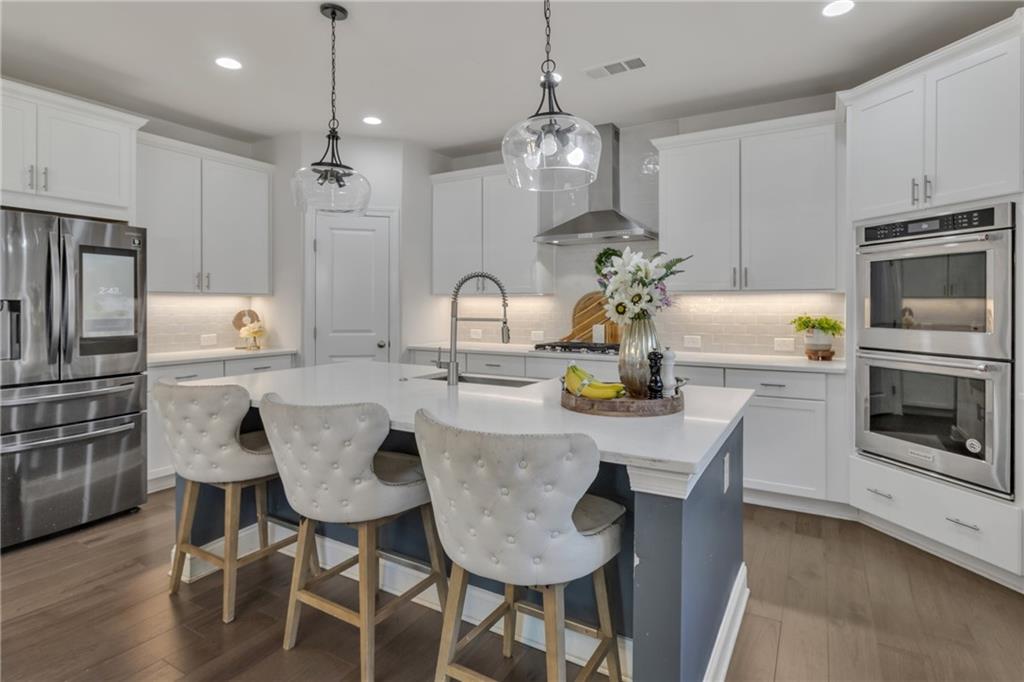 244 Wild Rose Circle Canton, GA 30115 - Photo 18 of 55 a kitchen with stainless steel appliances granite countertop a dining table chairs and refrigerator