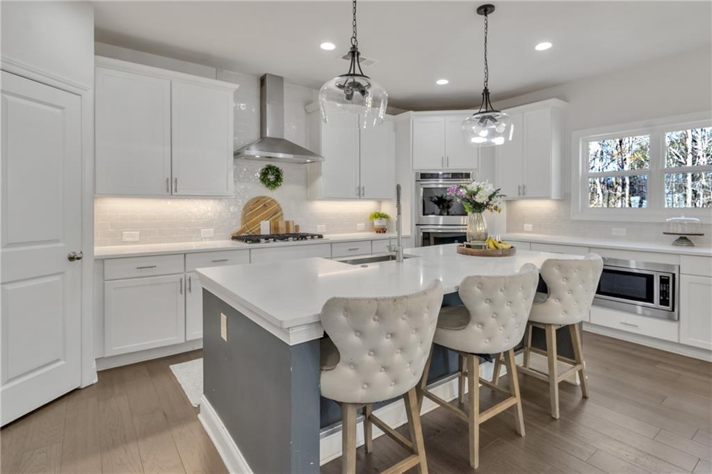244 Wild Rose Circle Canton, GA 30115 - Photo 19 of 55 a kitchen with kitchen island a dining table chairs stainless steel appliances and cabinets