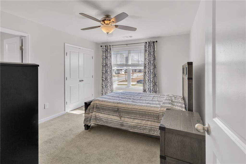 244 Wild Rose Circle Canton, GA 30115 - Photo 30 of 55 a spacious bedroom with a bed and a window