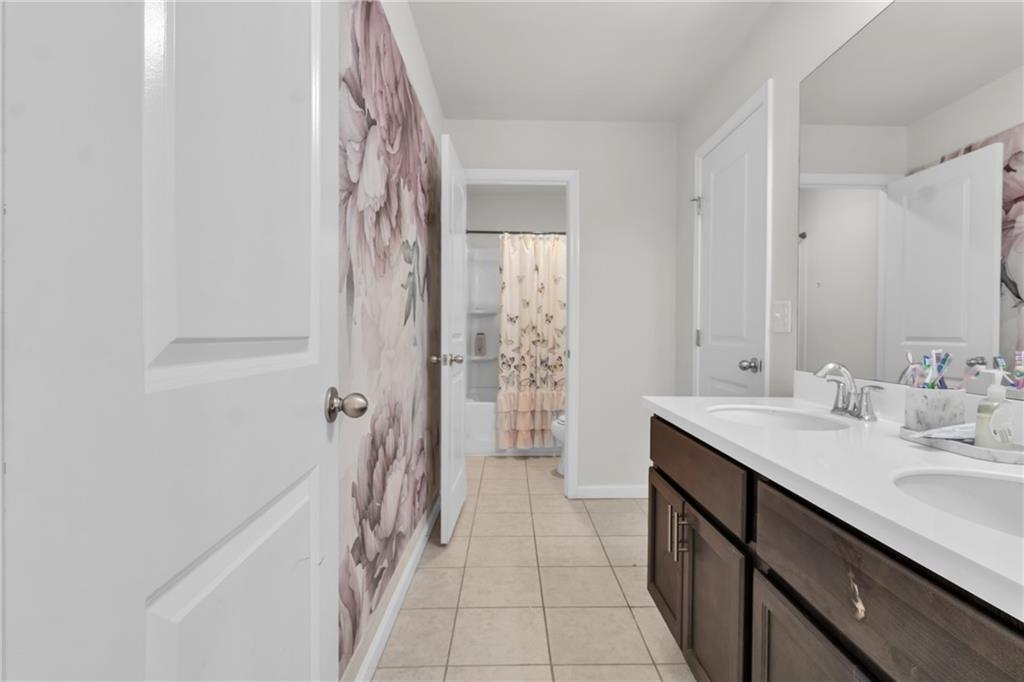 244 Wild Rose Circle Canton, GA 30115 - Photo 33 of 55 a bathroom with a double vanity sink a toilet and a shower