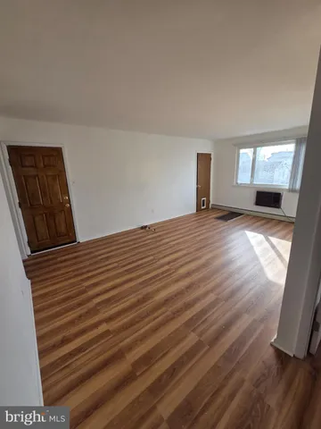 a view of a livingroom with wooden floor and window