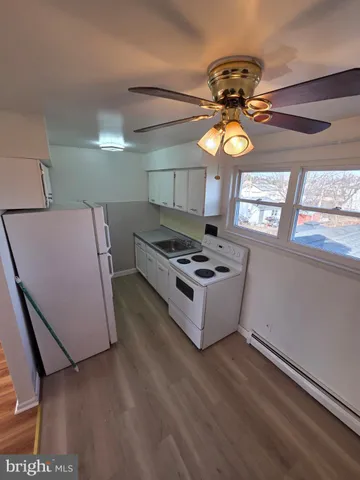 a kitchen with stainless steel appliances a stove a refrigerator cabinets and a chandelier