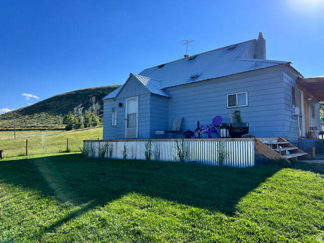 662 Earley Road Montpelier, ID 83254 - Photo 1 of 11 Back of property with a yard, a metal roof, a patio area, a mountain view, and a chimney