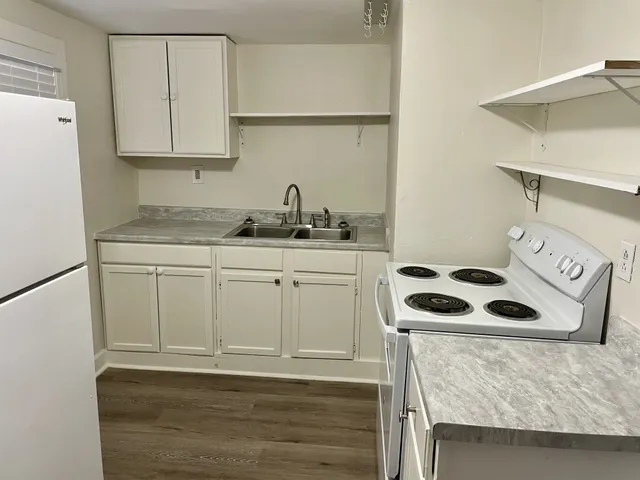 a kitchen with granite countertop a sink stove and refrigerator