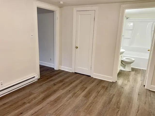 a view of a room with wooden floor and bathroom view