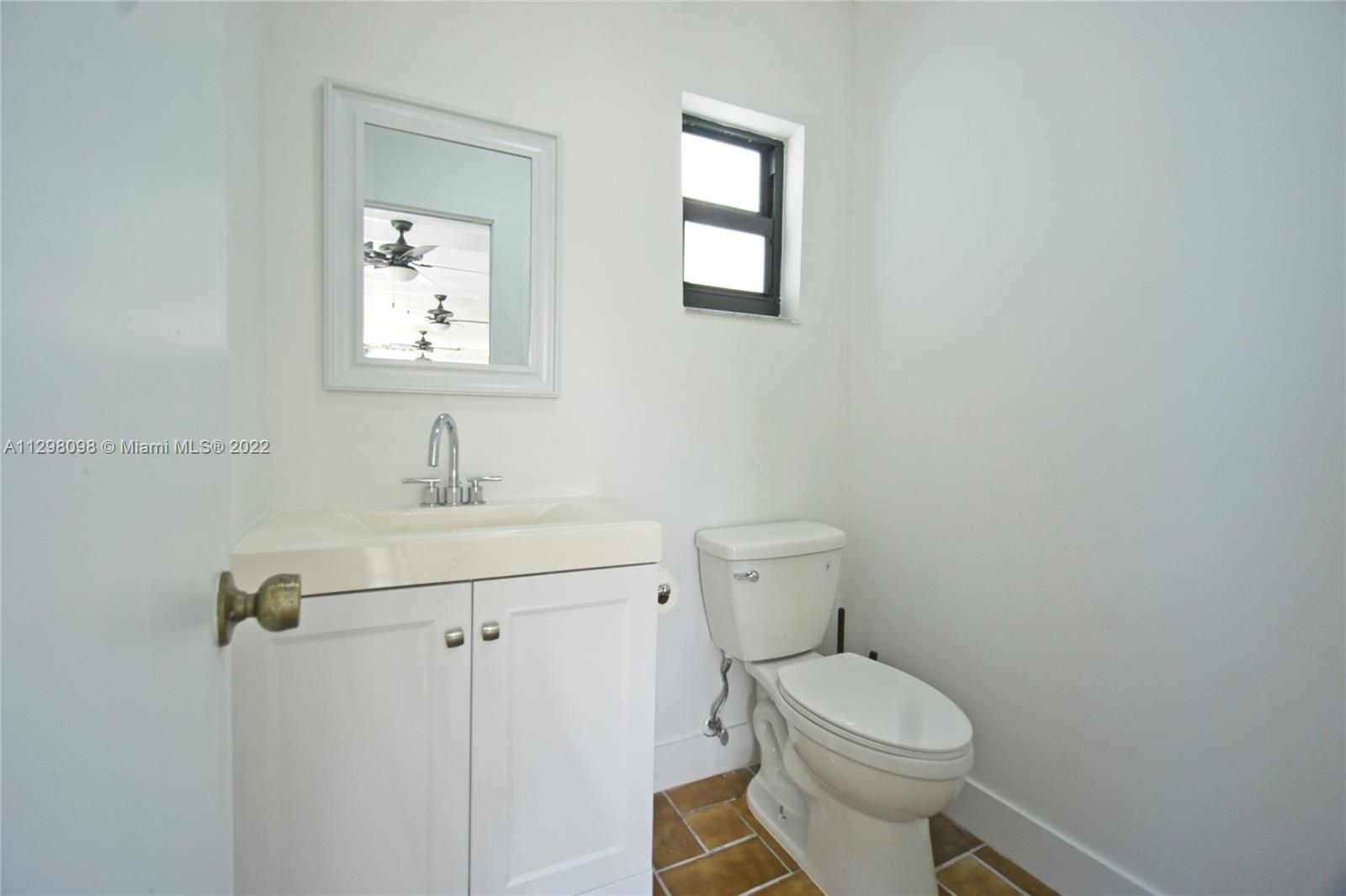 434 Southwest 23rd Road Miami, FL 33129 - Photo 19 of 32 a bathroom with a toilet a sink a mirror and vanity