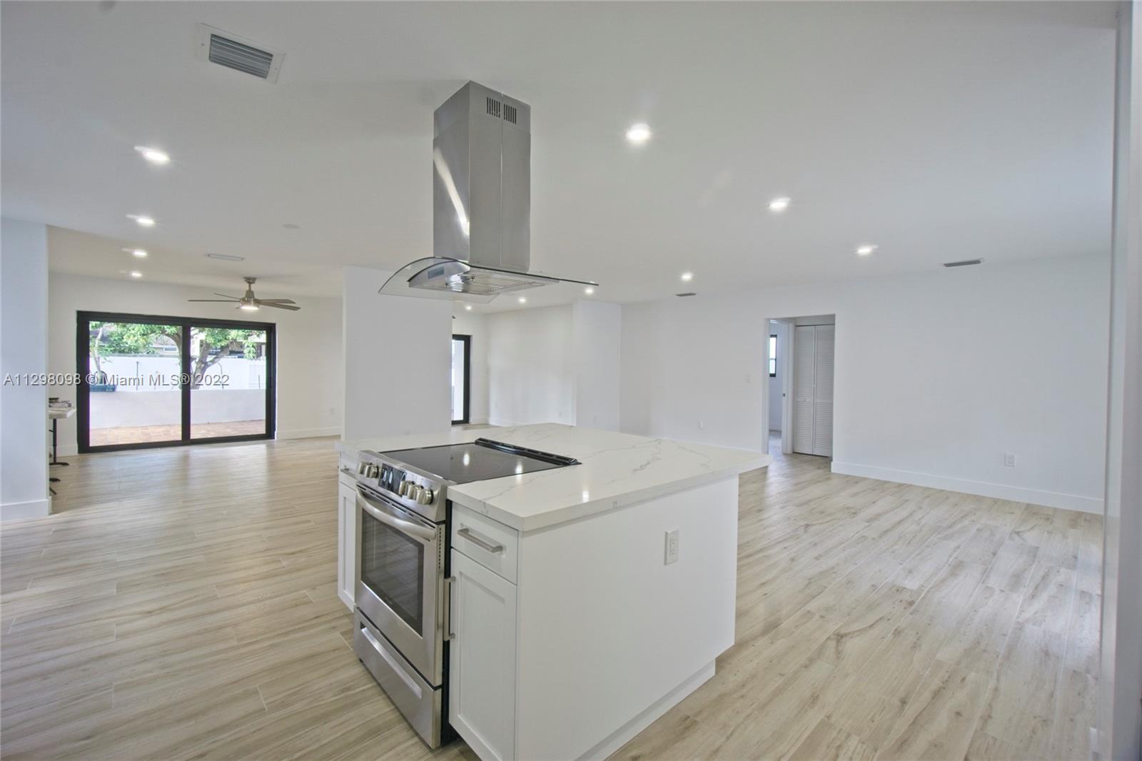 434 Southwest 23rd Road Miami, FL 33129 - Photo 5 of 32 a kitchen that has a lot of stainless steel appliances wooden floor and a window