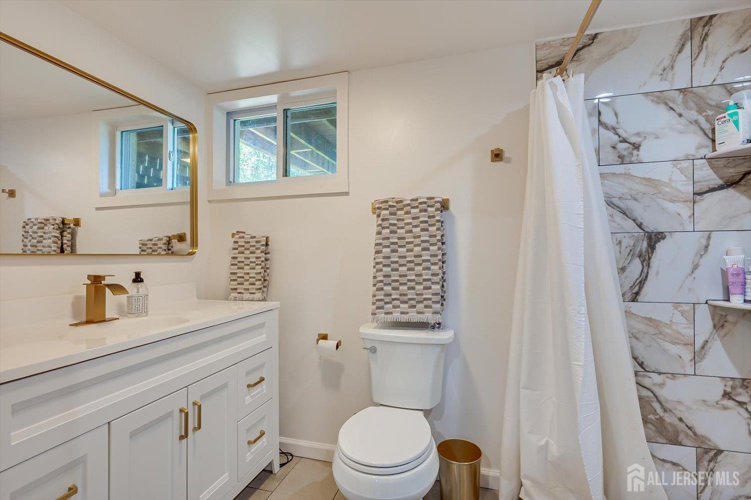 12 Gales Road Edison, NJ 08837 - Photo 27 of 35 a bathroom with a sink a toilet and shower curtain