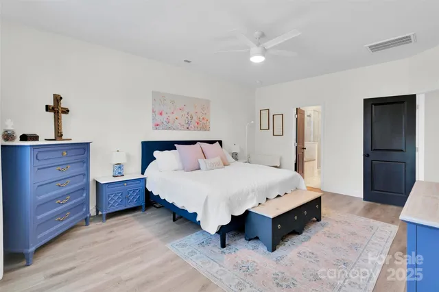 a spacious bedroom with a bed and a dresser