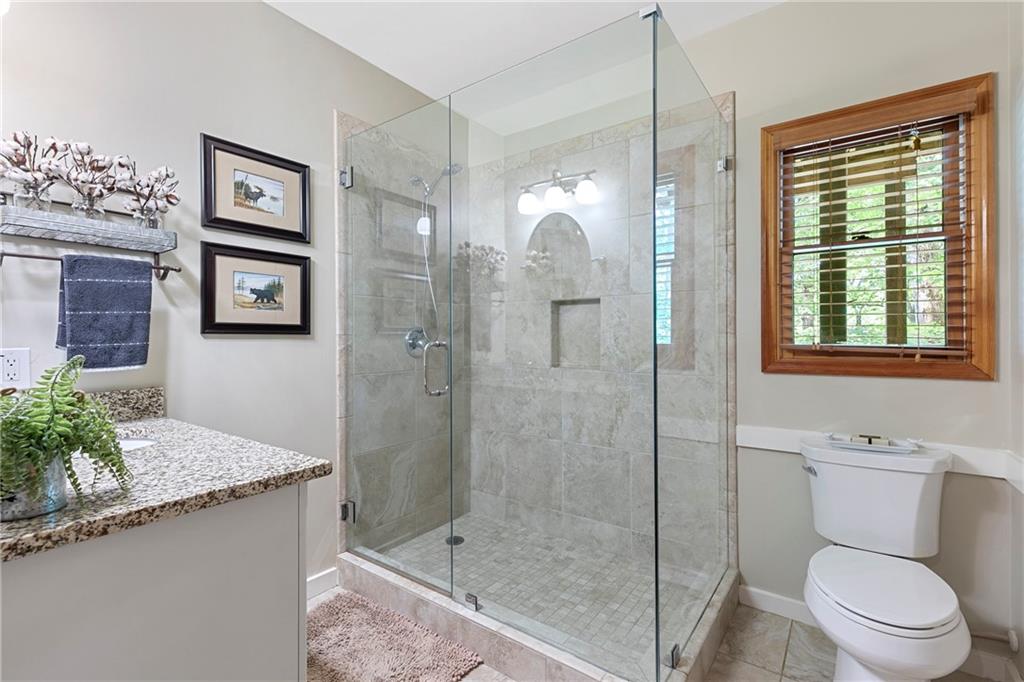 223 Denny Ridge Road Jasper, GA 30143 - Photo 26 of 54 a bathroom with a granite countertop sink a toilet and shower
