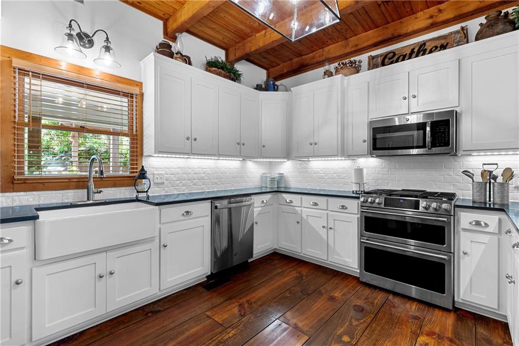 223 Denny Ridge Road Jasper, GA 30143 - Photo 8 of 54 a kitchen with granite countertop cabinets stainless steel appliances and wooden floor