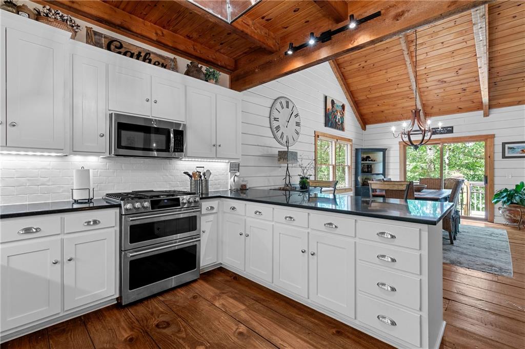 223 Denny Ridge Road Jasper, GA 30143 - Photo 9 of 54 a kitchen with granite countertop a sink a window stainless steel appliances and cabinets