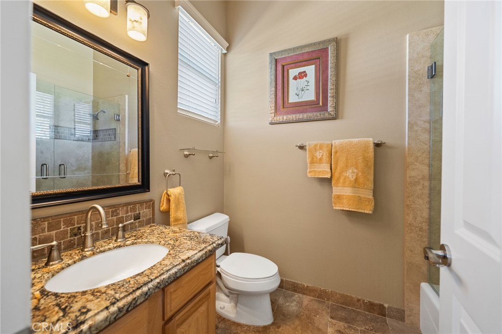 44195 Sunset Terrace Temecula, CA 92590 - Photo 32 of 74 a bathroom with a granite countertop toilet a sink and a mirror