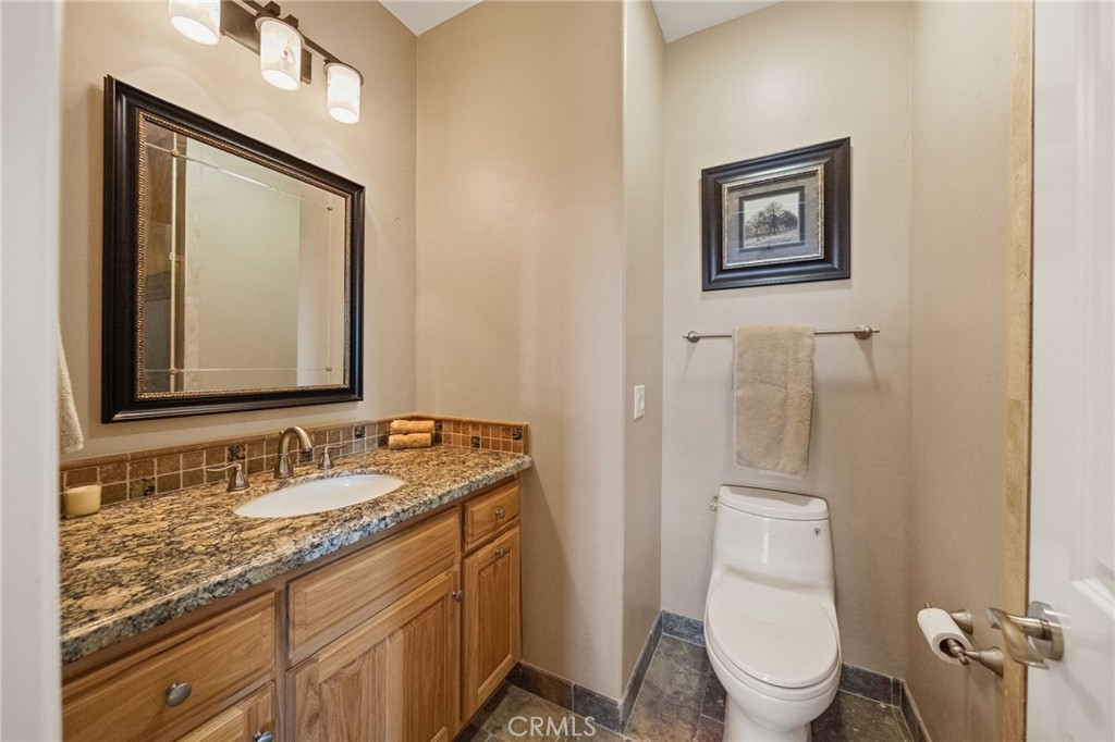 44195 Sunset Terrace Temecula, CA 92590 - Photo 50 of 74 a bathroom with a granite countertop toilet a sink and mirror