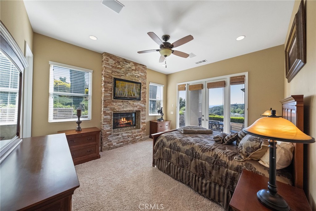 44195 Sunset Terrace Temecula, CA 92590 - Photo 51 of 74 a spacious bedroom with a bed a table and a fireplace