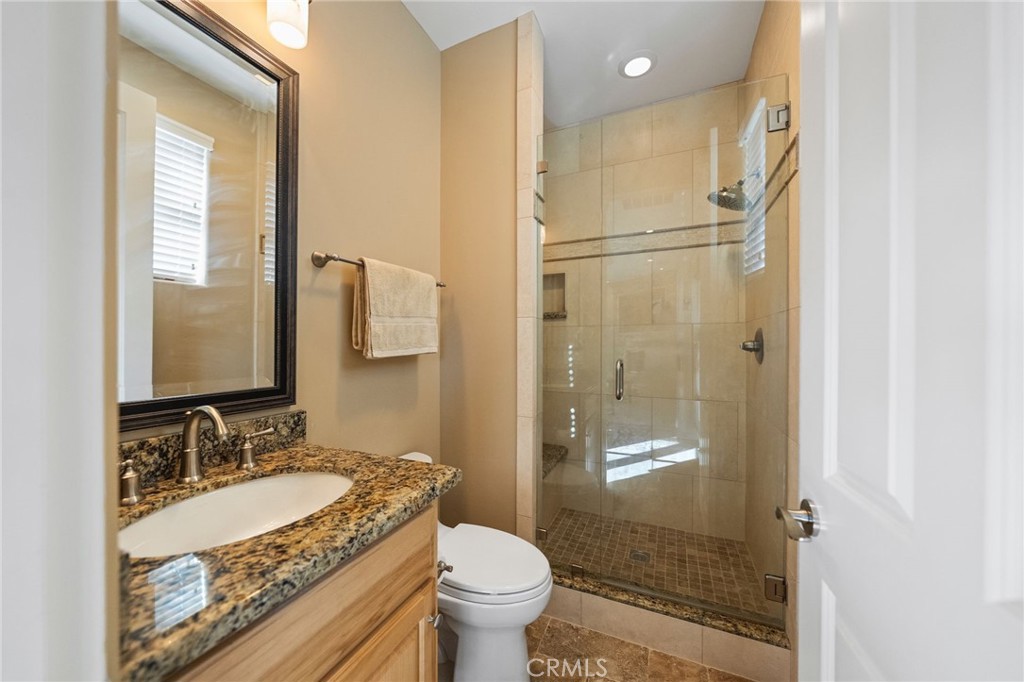 44195 Sunset Terrace Temecula, CA 92590 - Photo 63 of 74 a bathroom with a granite countertop sink toilet and shower glass cabinet