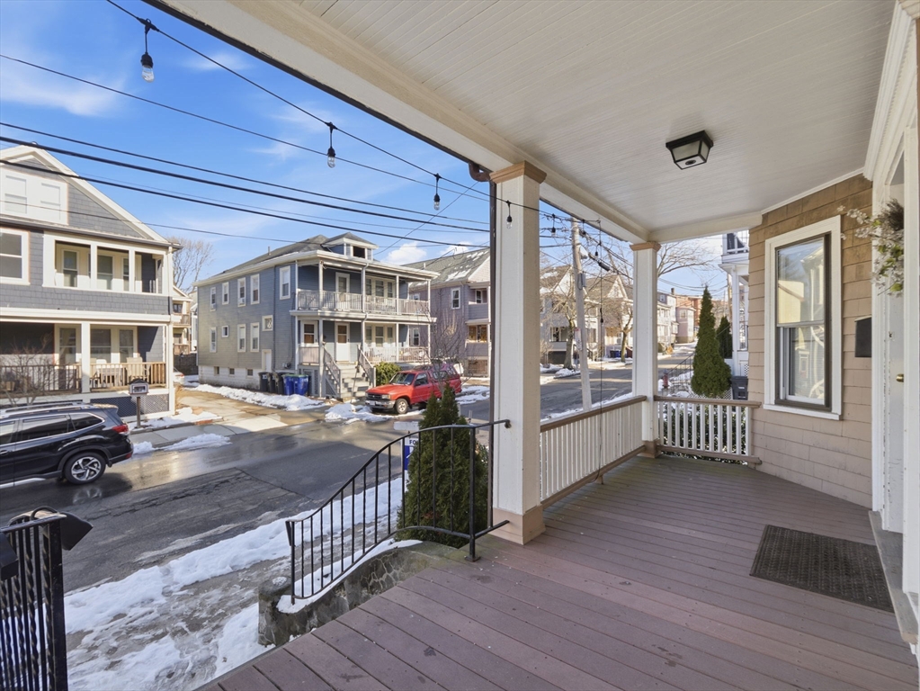28 Sunset Road, Unit 1 Somerville, MA 02144 - Photo 24 of 33 a view of a porch with wooden floor and iron stairs