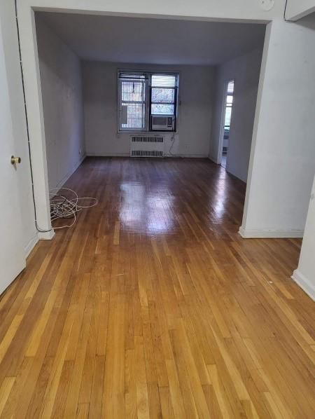 37-30 83rd Street, Unit 2M Queens, NY 11372 - Photo 8 of 20 an empty room with wooden floor and windows