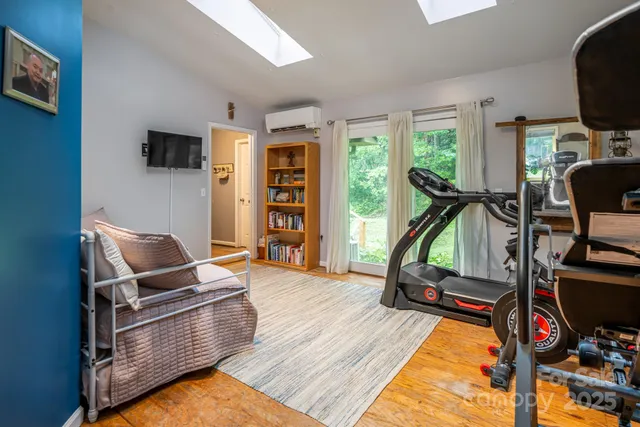 a living room with furniture a wooden floor and a large window