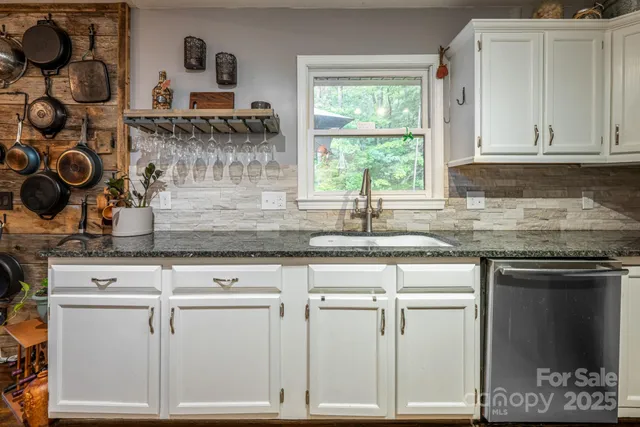 a kitchen with stainless steel appliances kitchen island granite countertop a stove a microwave a dining table and chairs with wooden floor