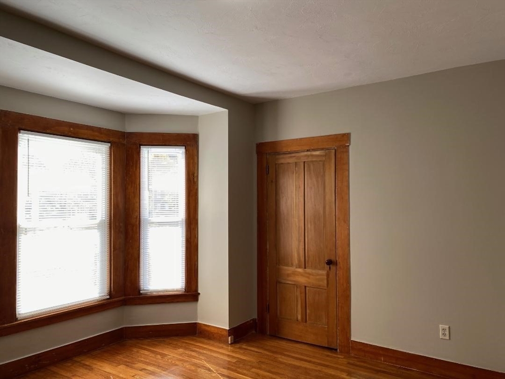 16 Ruggles Street, Unit 1 Westborough, MA 01581 - Photo 12 of 22 an empty room with wooden floor and windows