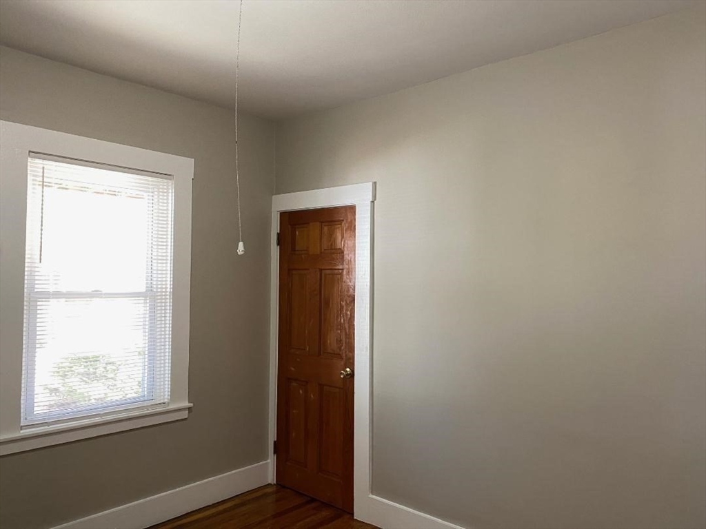 16 Ruggles Street, Unit 1 Westborough, MA 01581 - Photo 18 of 22 an empty room with wooden floor and windows