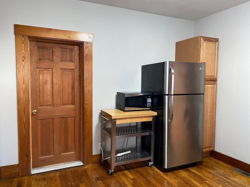 16 Ruggles Street, Unit 1 Westborough, MA 01581 - Photo 2 of 22 a view of a kitchen with wooden floor and a refrigerator