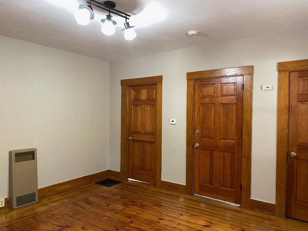 16 Ruggles Street, Unit 1 Westborough, MA 01581 - Photo 5 of 22 an empty room with wooden floor cabinet and windows