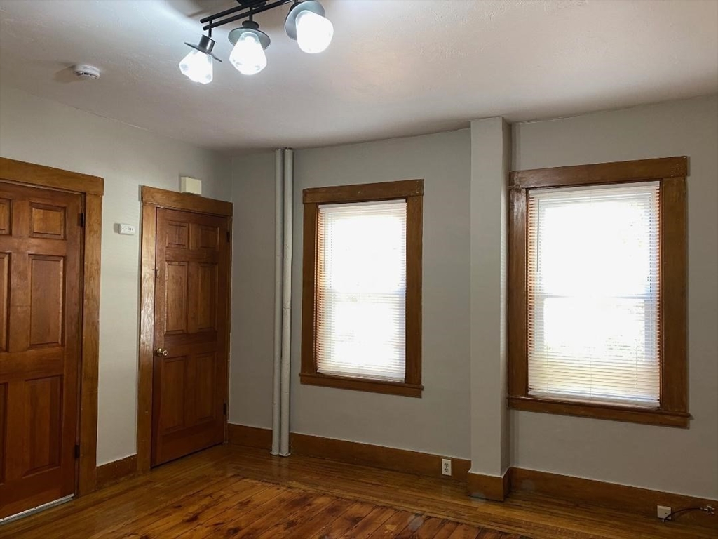 16 Ruggles Street, Unit 1 Westborough, MA 01581 - Photo 6 of 22 an empty room with wooden floor and windows