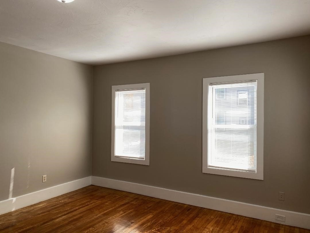 16 Ruggles Street, Unit 1 Westborough, MA 01581 - Photo 8 of 22 a view of an empty room with wooden floor and a window