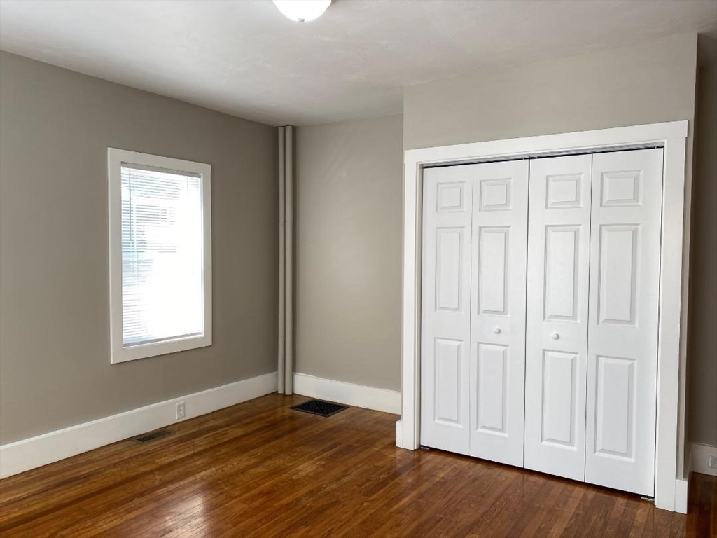 16 Ruggles Street, Unit 1 Westborough, MA 01581 - Photo 9 of 22 an empty room with wooden floor and closet area