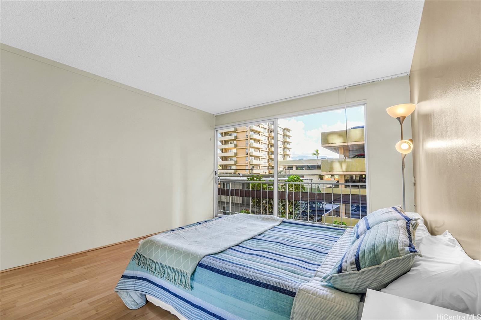 431 Nāhua Street, Unit 309 Honolulu, HI 96815 - Photo 12 of 25 a bed sitting in a bedroom next to a window