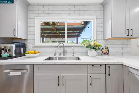 a kitchen with a sink window and cabinets