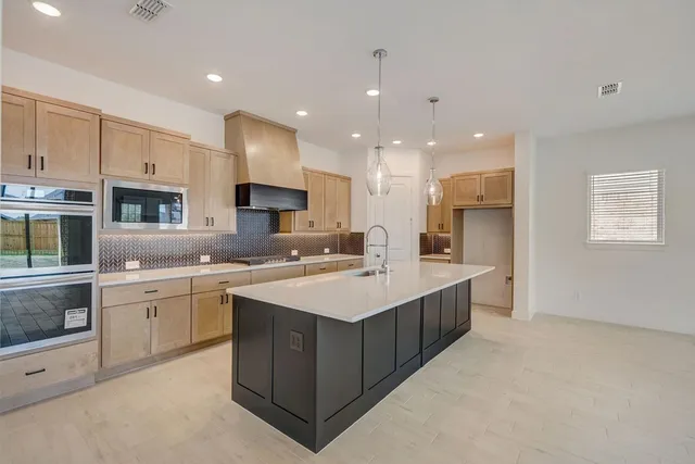 a large kitchen with a sink and cabinets