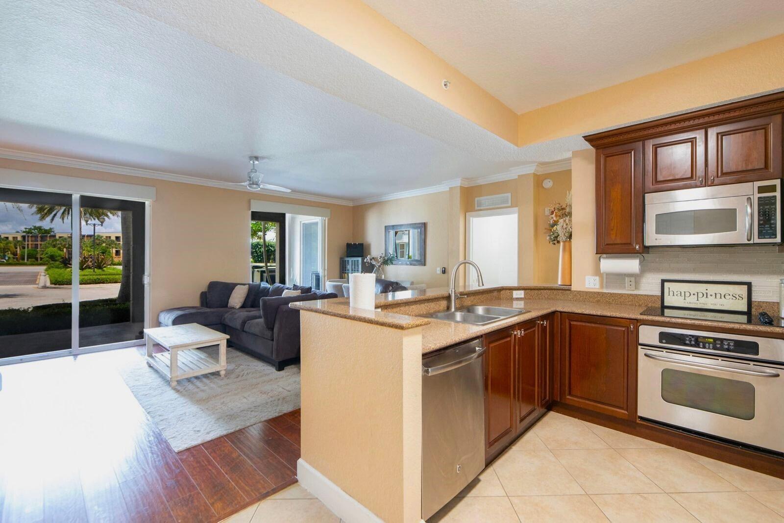 3107 Renaissance Way Boynton Beach, FL 33426 - Photo 11 of 37 a kitchen with stainless steel appliances granite countertop a stove top oven a sink dishwasher and cabinets with wooden floor