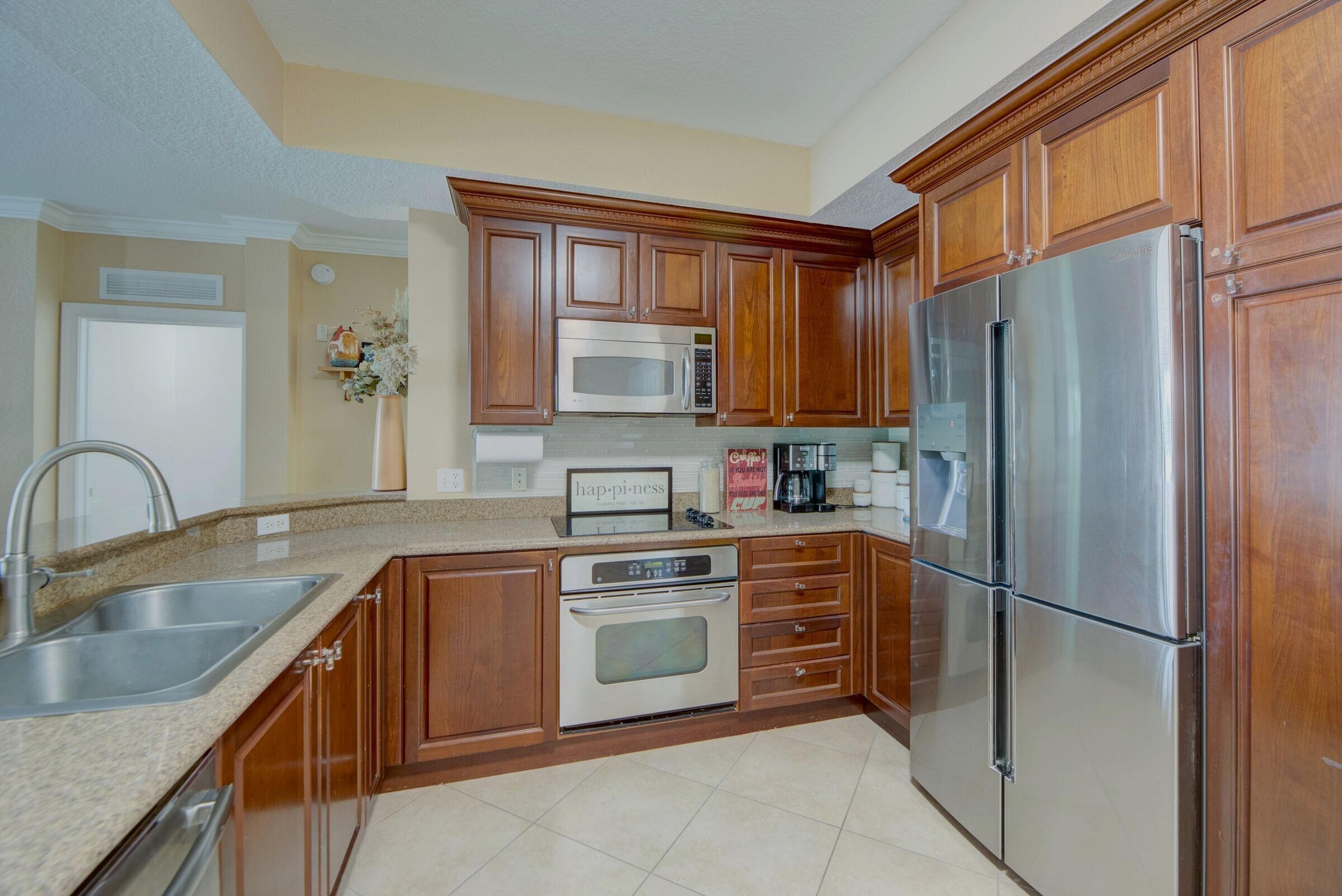 3107 Renaissance Way Boynton Beach, FL 33426 - Photo 10 of 37 a kitchen with stainless steel appliances granite countertop a refrigerator sink and cabinets