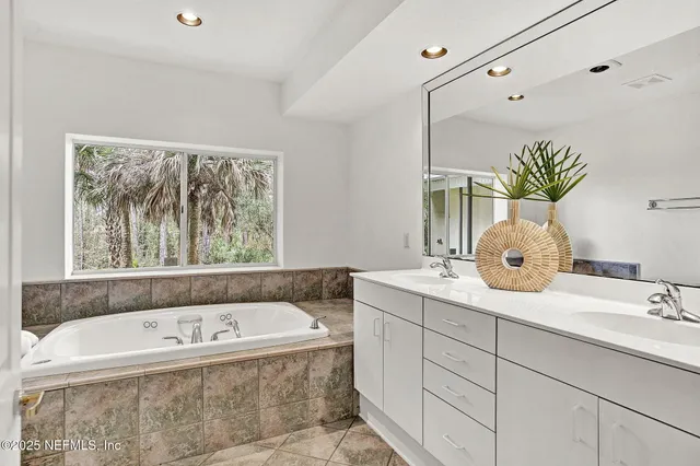 a bathroom with a granite countertop sink and a large mirror