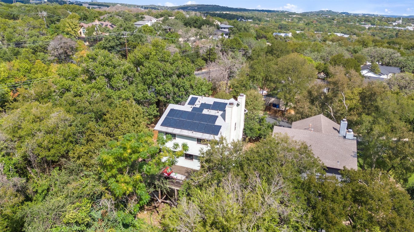an aerial view of residential house with outdoor space and trees all around