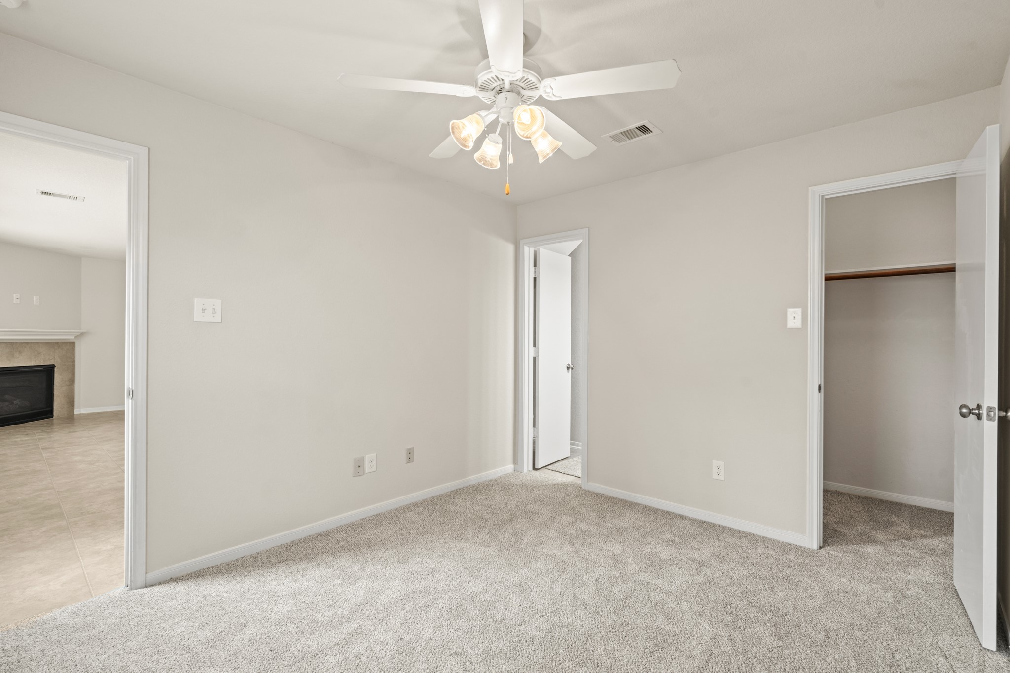 3118 Winchester Rnch Trail Katy, TX 77493 - Photo 11 of 22 A second view of this downstairs bedroom reveals its generous size, plush carpet, ceiling fan, en-suite or adjacent bathroom access, and a walk-in closet — providing comfortable accommodations for guests or family members who prefer first-floor living.