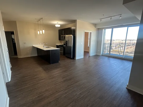 a view of a kitchen with stainless steel appliances wooden floor and a large window
