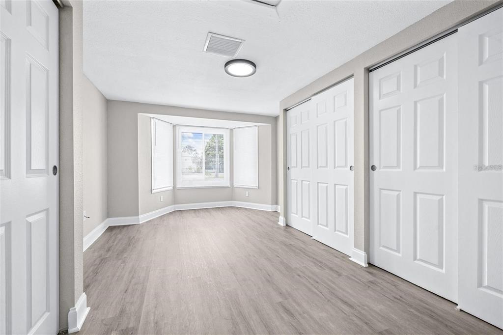 13926 Helen Avenue Hudson, FL 34667 - Photo 11 of 44 an empty room with wooden floor and windows