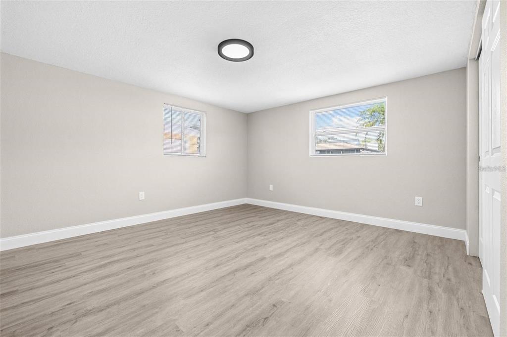 13926 Helen Avenue Hudson, FL 34667 - Photo 14 of 44 an empty room with wooden floor and windows