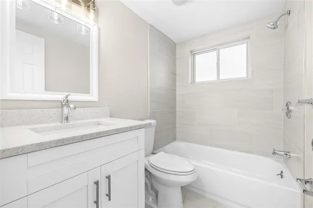 a bathroom with a granite countertop sink a toilet and shower