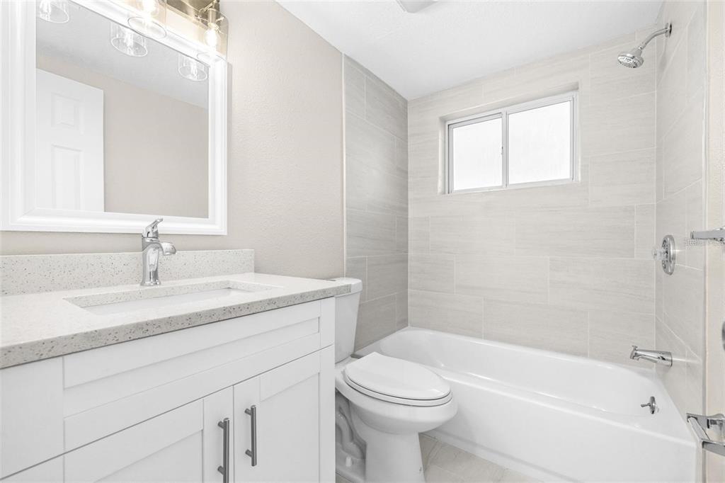 13926 Helen Avenue Hudson, FL 34667 - Photo 16 of 44 a bathroom with a granite countertop sink a toilet and shower