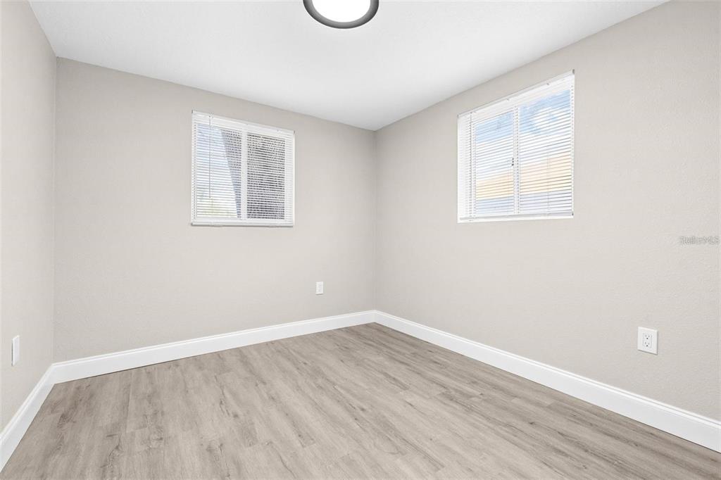 13926 Helen Avenue Hudson, FL 34667 - Photo 17 of 44 an empty room with wooden floor and windows