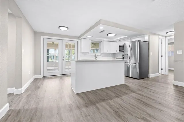 a kitchen with stainless steel appliances granite countertop a refrigerator and a stove top oven