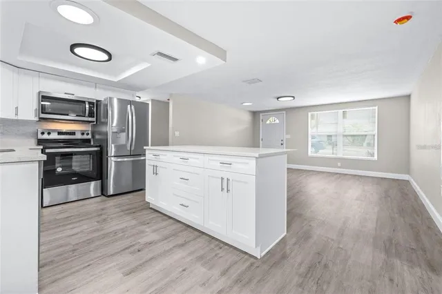 a kitchen with stainless steel appliances a stove top oven and refrigerator