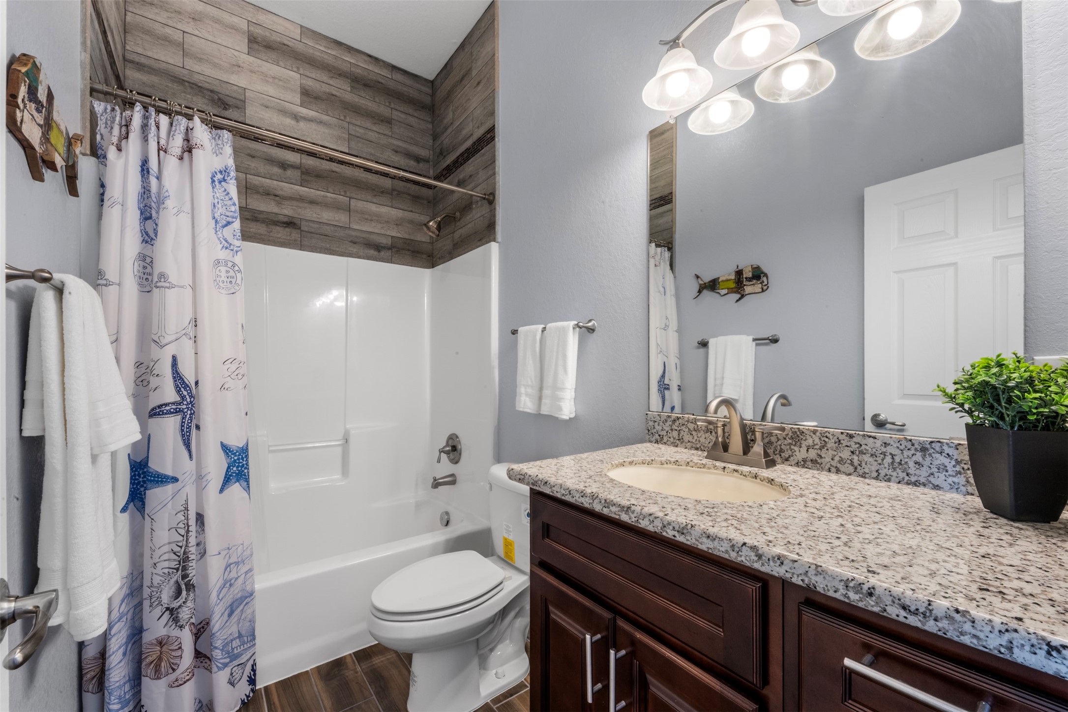 1026 20th Street Dickinson, TX 77539 - Photo 12 of 25 a bathroom with a granite countertop sink toilet and shower
