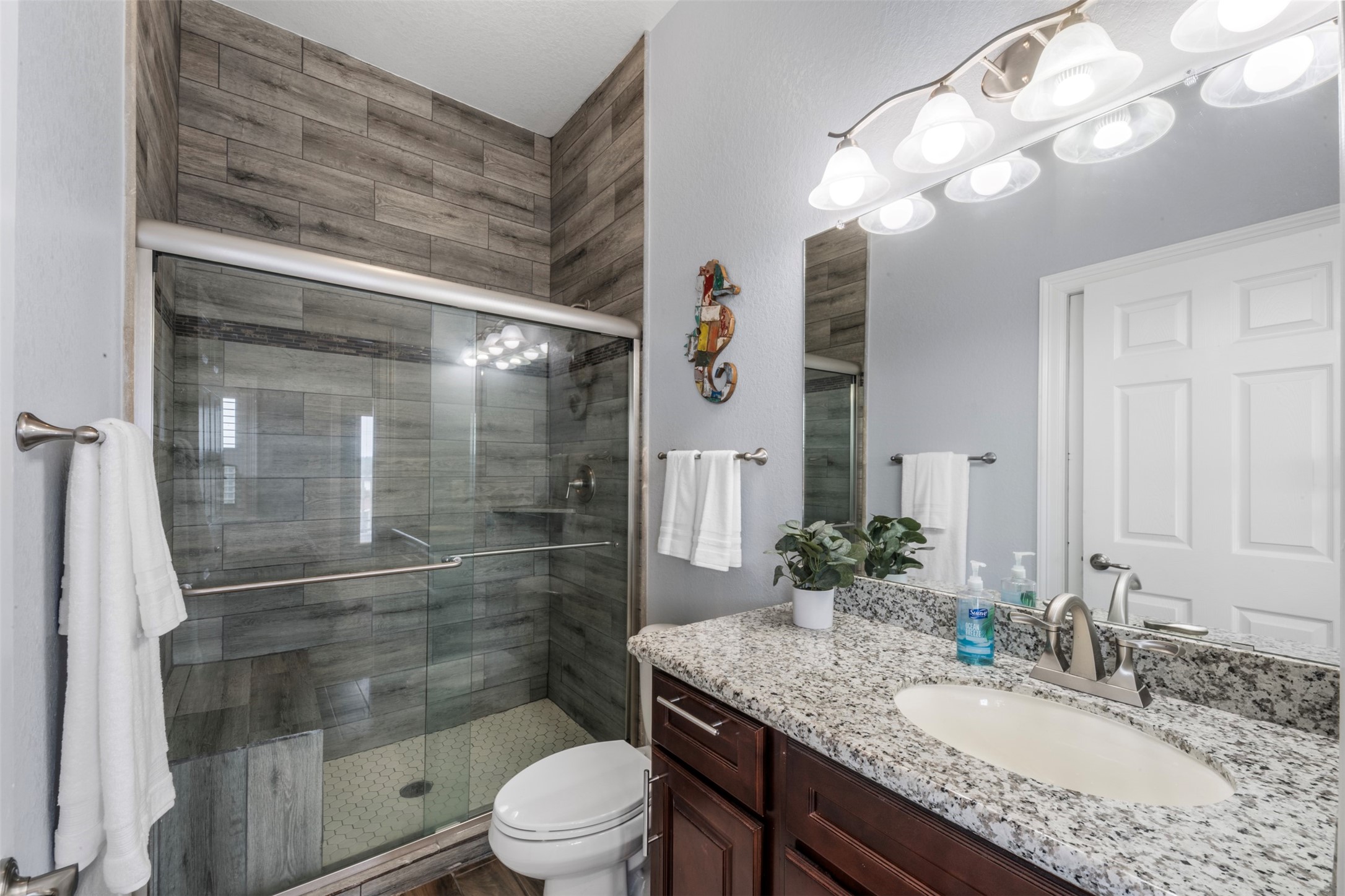 1026 20th Street Dickinson, TX 77539 - Photo 16 of 25 a bathroom with a granite countertop sink a toilet and shower